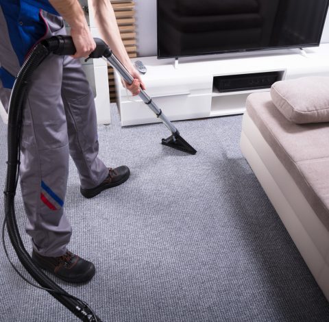 Janitor Cleaning Carpet With Vacuum Cleaner Close-up Of A Male Janitor Using Vacuum Cleaner For Cleaning The Carpet In Living Room