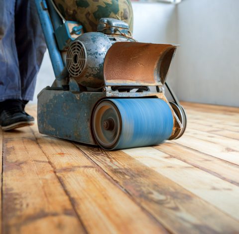 home renovation, parquet sanding, polishing Worker polishing parquet floor with grinding machine